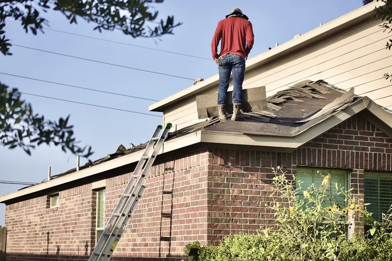 Professional roofer working on a residential roof in Loree